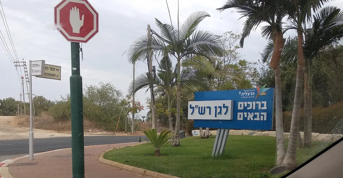 Municipal "Welcome to Gan Rashal" sign among palms at the neighbourhood entrance, Herzliya